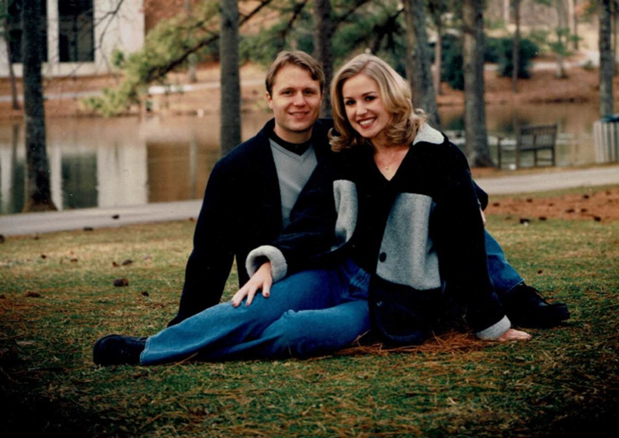 Couple sits in the grass for photo