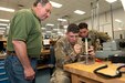 Photo of Electronics Mechanic Leader overseeing Soldiers during a side-by-side training effort.