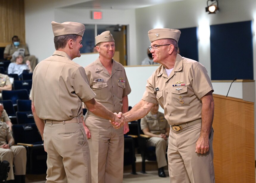 Rear Adm. Curt Copley (center) assumed command of the Office of Naval Intelligence and directorship of the National Maritime Intelligence-Integration Office during a ceremony June 18 at the National Maritime Intelligence Center in Suitland, Md. Deputy Chief of Naval Operations for Information Warfare and Director of Naval Intelligence Vice Adm. Jeffrey Trussler (right), the guest speaker, congratulates Rear Adm. Price (left) for taking the helm for the second time and seamlessly leading the organizations through another leadership transition.