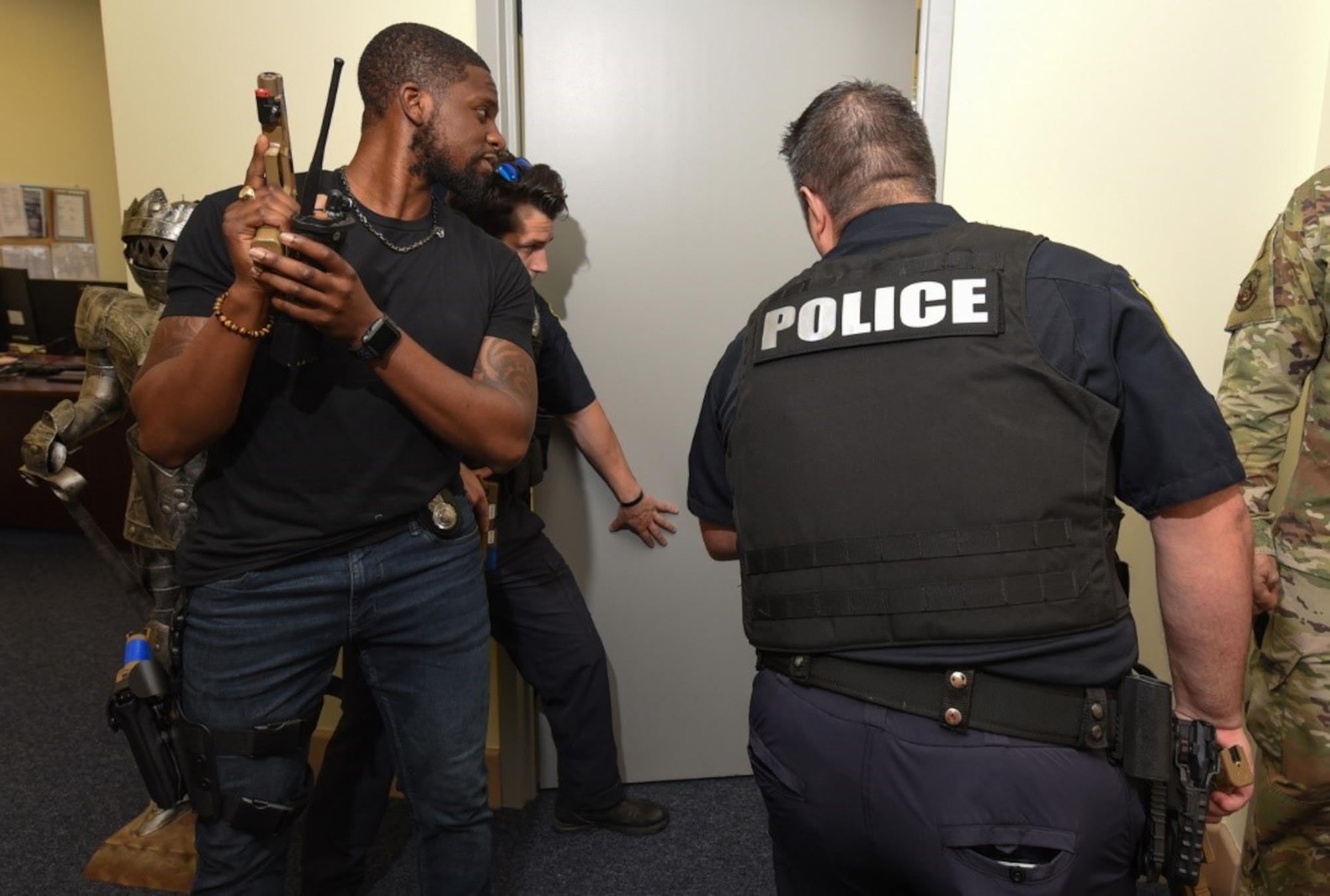 66th Security Forces Squadron Staff Sgt. Charles Williams, left, investigator, Officer Jonathan Stearns, and Police Cpl. Ali Zariv, lead police officer, breach a door in the 66 SFS building during an active shooter exercise scenario at Hanscom Air Force Base, Mass., June 23 Hanscom AFB conducted various base exercise scenarios June 23-24 to evaluate the installation’s readiness and emergency response capabilities. (U.S. Air Force photo by Todd Maki)