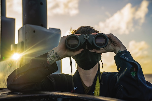 Logistics Specialist (Submarine) 1st Class Anna Donelan, assigned to Gold crew of Ohio-class guided-missile submarine USS Ohio, scans for contacts while standing lookout watch on bridge, Pacific Ocean, January 22, 2021 (U.S. Navy/Kelsey J. Hockenberger)