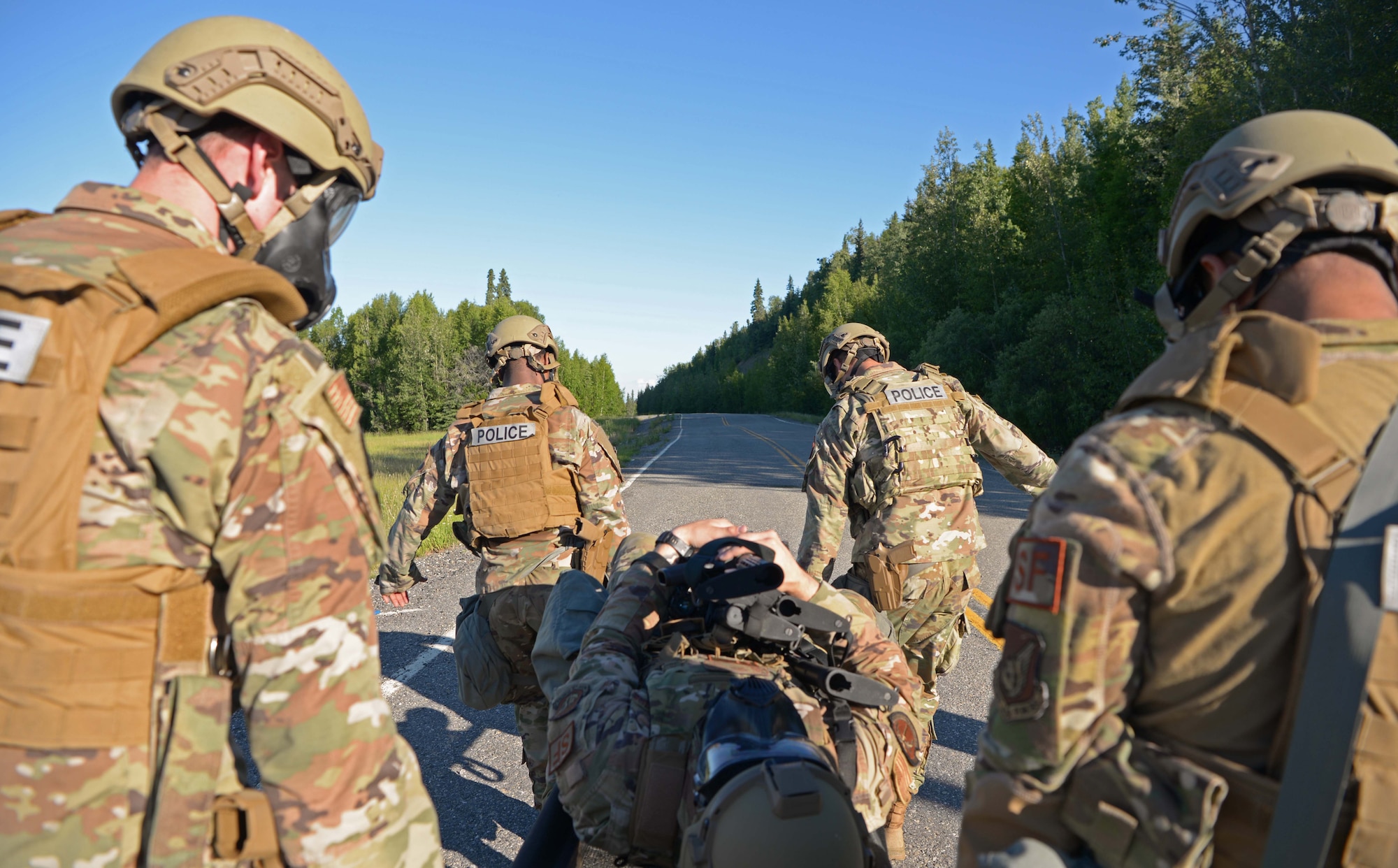 U.S. Air Force Airmen from the 354th Security Forces Squadron (SFS) carry a simulated casualty during special weapons and tactics (SWAT) training June 23, 2021 on Eielson Air Force Base, Alaska. The defenders took turns carrying a simulated casualty for approximately .75 miles to complete the SWAT training. (U.S. Air Force photo by Senior Airman Beaux Hebert)