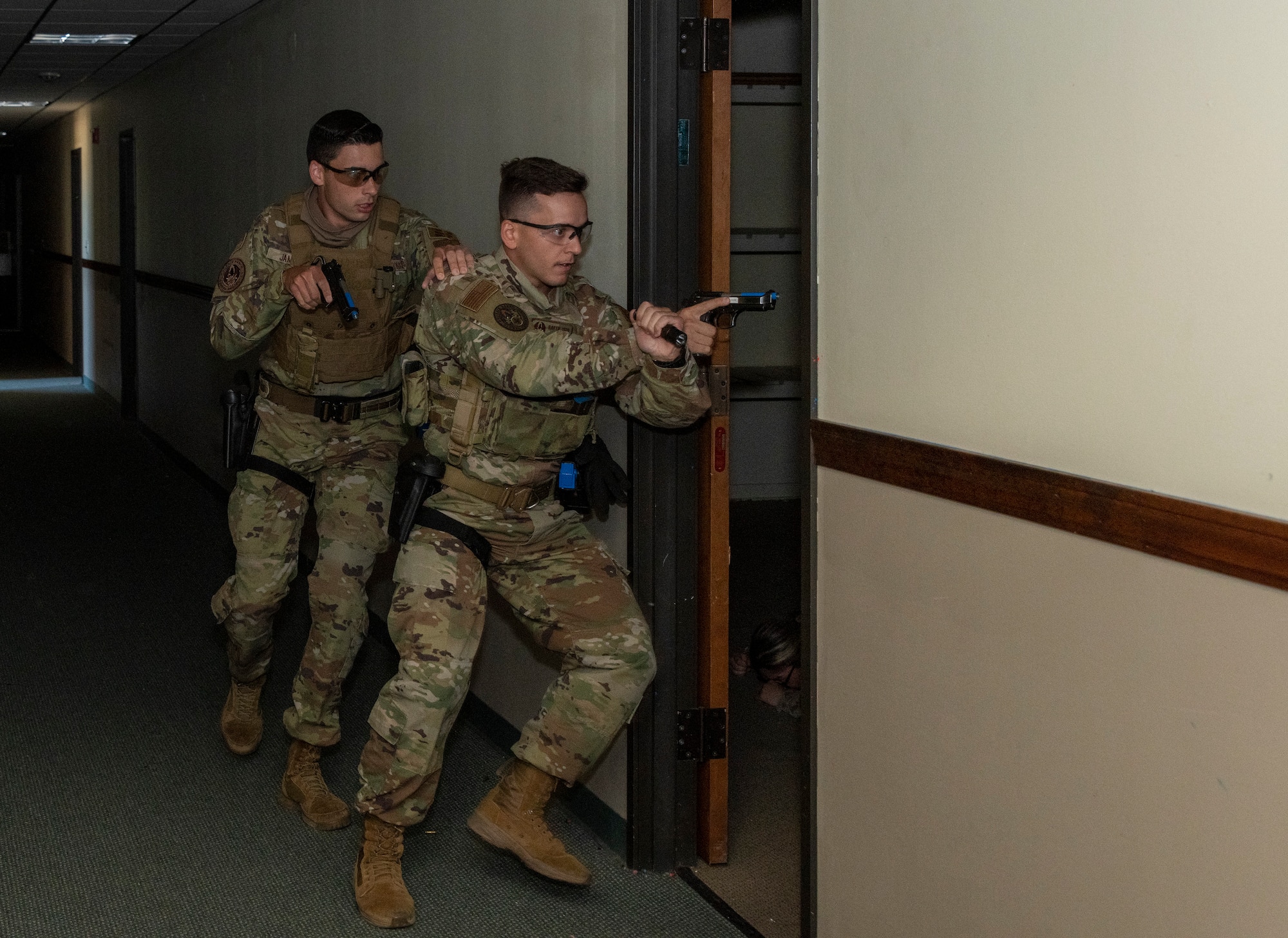 Airman 1st Class Seth James, left, and Senior Airman Jared Hawley, both Phoenix Raven team members with the 60th Security Forces Squadron, search for threats during a crucible training demonstration June 24, 2021, at Travis Air Force Base, California. The crucible is a highly intense scenario intentionally designed to stress participants to improve proficiency in responding to emergencies. (U.S. Air Force photo by Heide Couch)