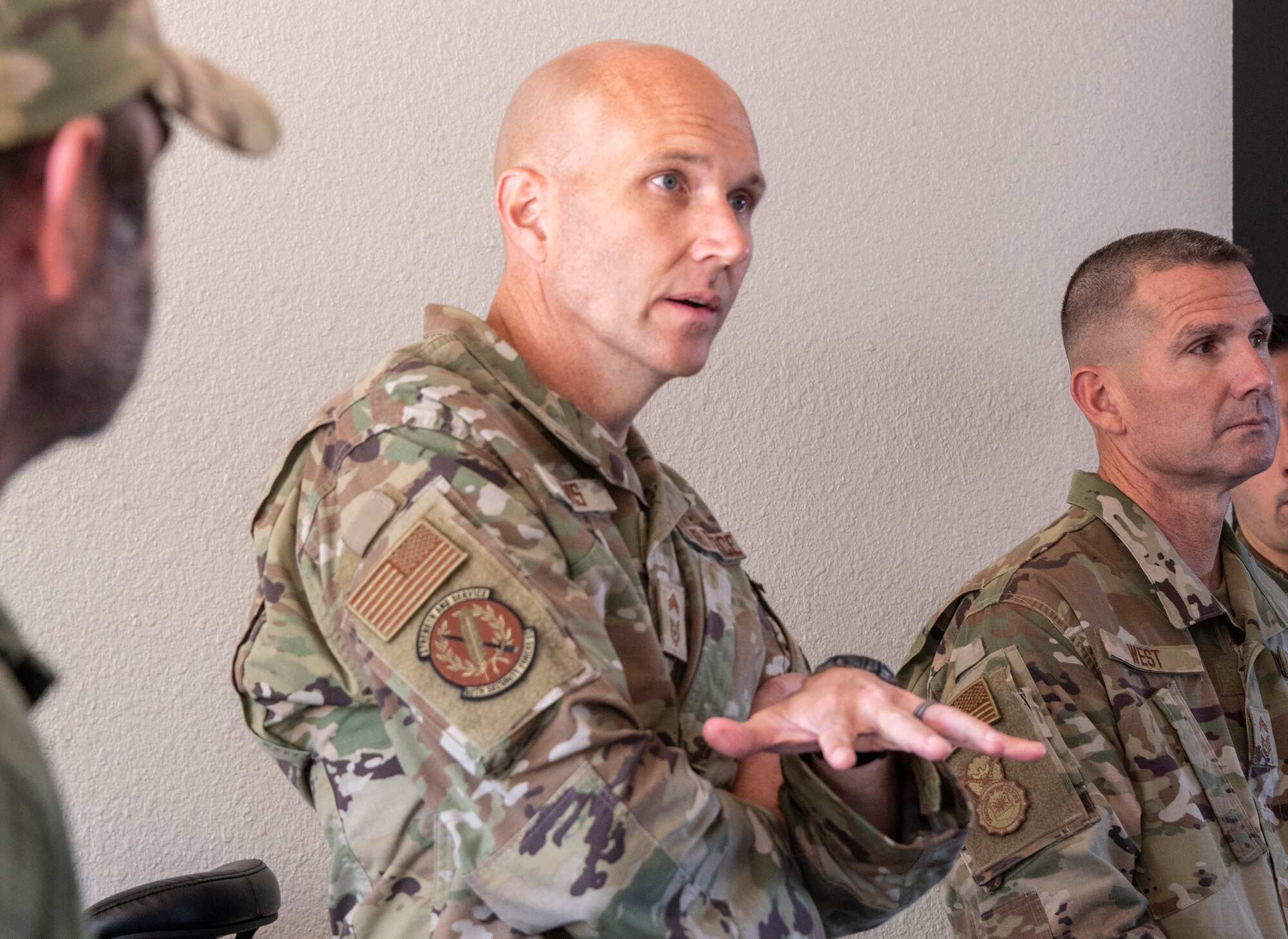 U.S. Air Force Chief Master Sgt. Brian Lewis, center, Security Forces career field manager, and Chief Master Sgt. Steven West, right, mobilization augmentee to the Security Forces career field manager, speak with Security Forces Airmen during a visit to Travis Air Force Base, California, June 24, 2021. Lewis and West visited Travis AFB to better understand the base defense culture and observe how the members of its Security Forces perform their mission. (U.S. Air Force photo by Heide Couch)