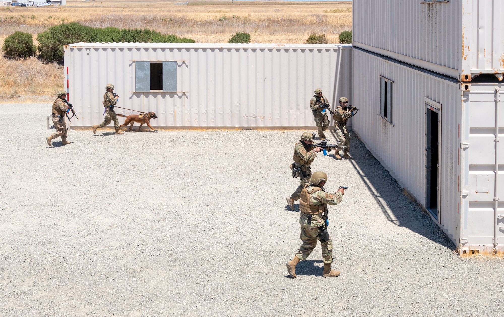 Members assigned to the 60th Security Forces Squadron search for threats during active shooter training June 24, 2021, at the Emergency Responder Urban Training Site, Travis Air Force Base, California. Made out of fabricated shipping containers, the ERUTS is intended to provide emergency responders with a wide variety of layouts and the capability to conduct full-scale scenarios. (U.S. Air Force photo by Heide Couch)