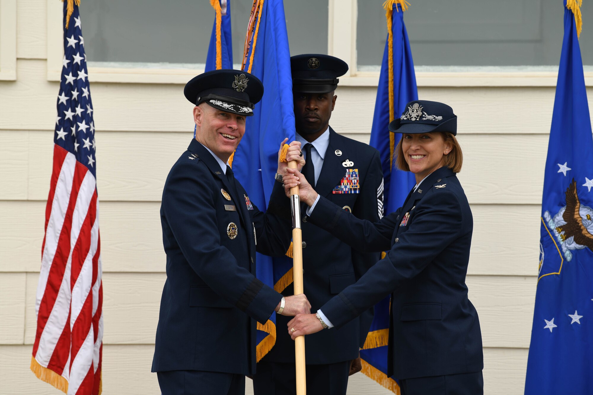 Maj. Gen. Michael Lutton, 20th Air Force commander, passes the guidon to Col. Catherine Barrington, 90th Missile Wing commander, during the 90 MW change of command ceremony June 28, 2021, F.E. Warren Air Force Base, Wyoming. The ceremony signified the transition of command from Col. Peter Bonetti to Col. Catherine Barrington. (U.S. Air Force photo by Airman 1st Class Anthony Munoz)