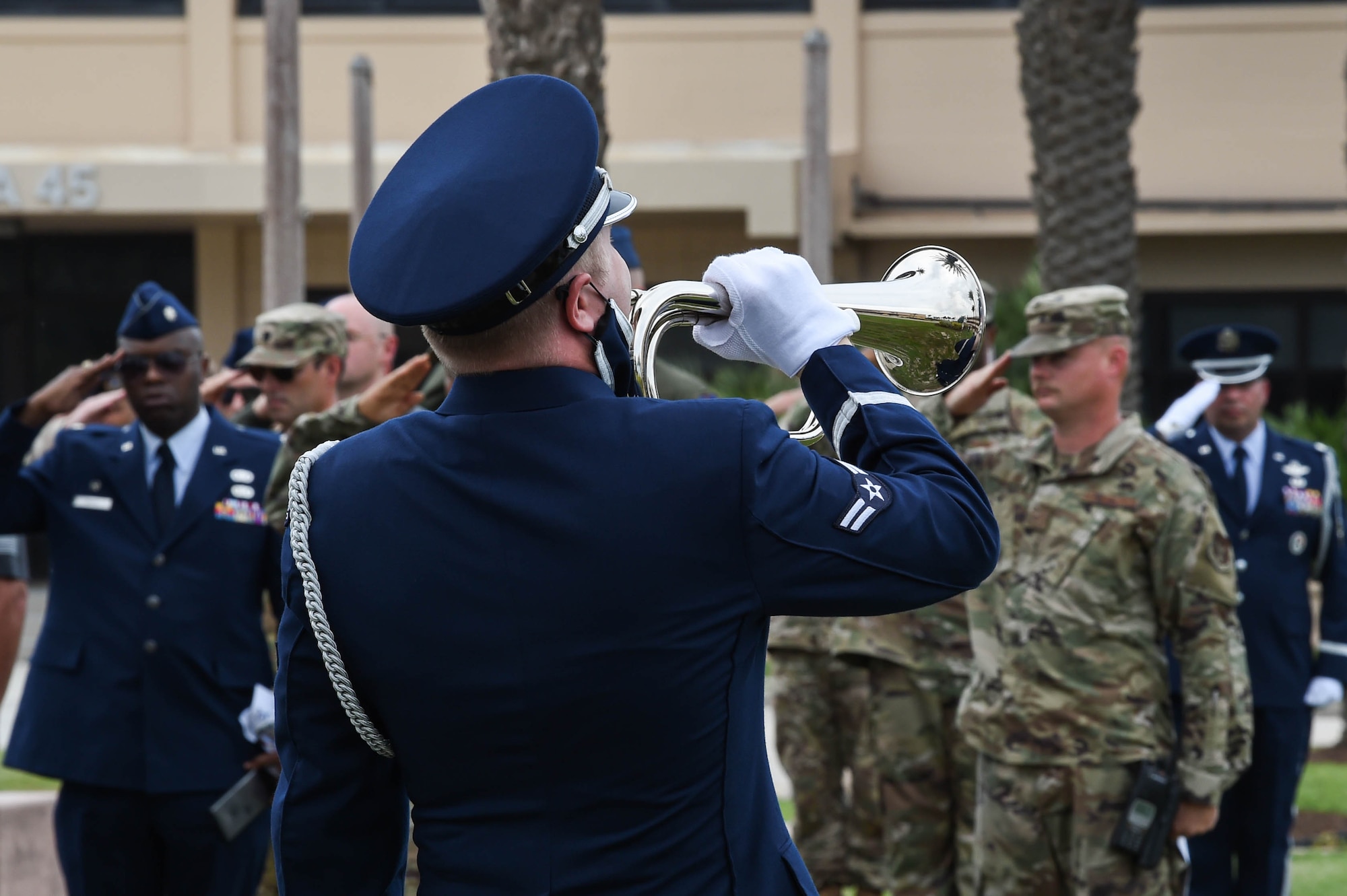 An Airman plays Taps at a memorial ceremony