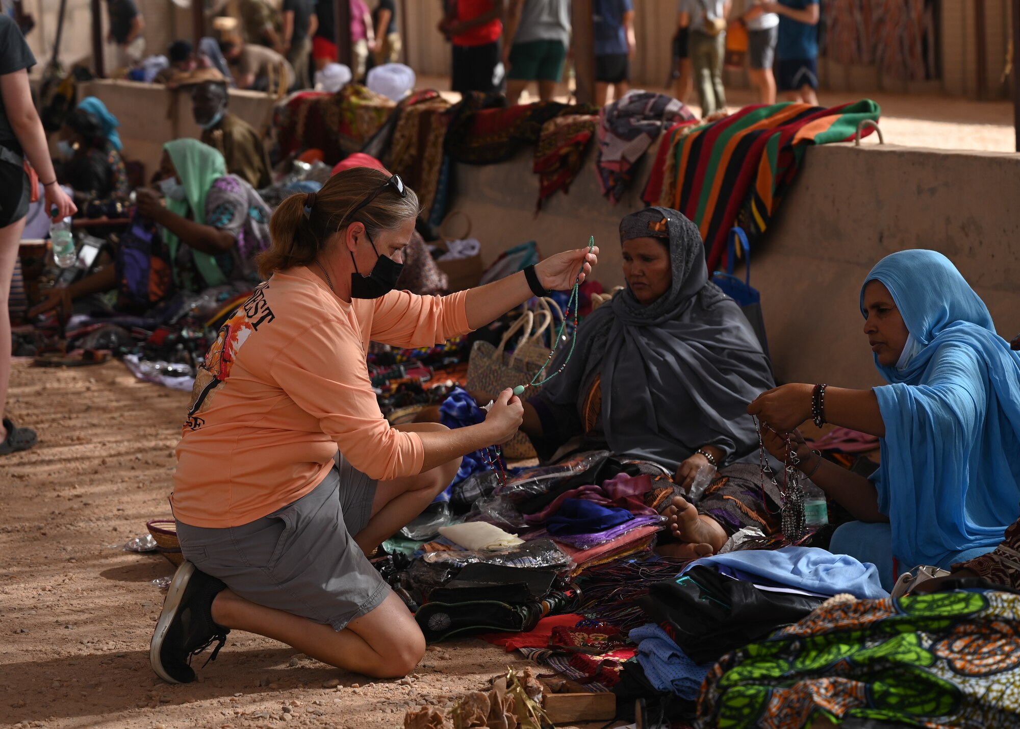A U.S. service member assigned to Nigerien Air Base 201 browses through a vendor’s inventory during a bazaar at the base in Agadez, Niger, June 20, 2021. Members of Air Base 201 successfully injected more than 4.2 million West African CFA Franc which is approximately 14 thousand dollars into the local economy.(U.S. Air Force photo by Airman 1st Class Jan K. Valle)