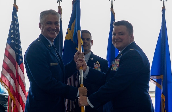 U.S. Air Force Brig. Gen. Jeremy Sloane, 36th Wing commander, passes the 6th Mission Support Group guidon to U.S. Air Force Col. Kenneth Herndon, 36th MSG incoming commander, during a change of command ceremony at Andersen Air Force Base, Guam, June 29, 2021.