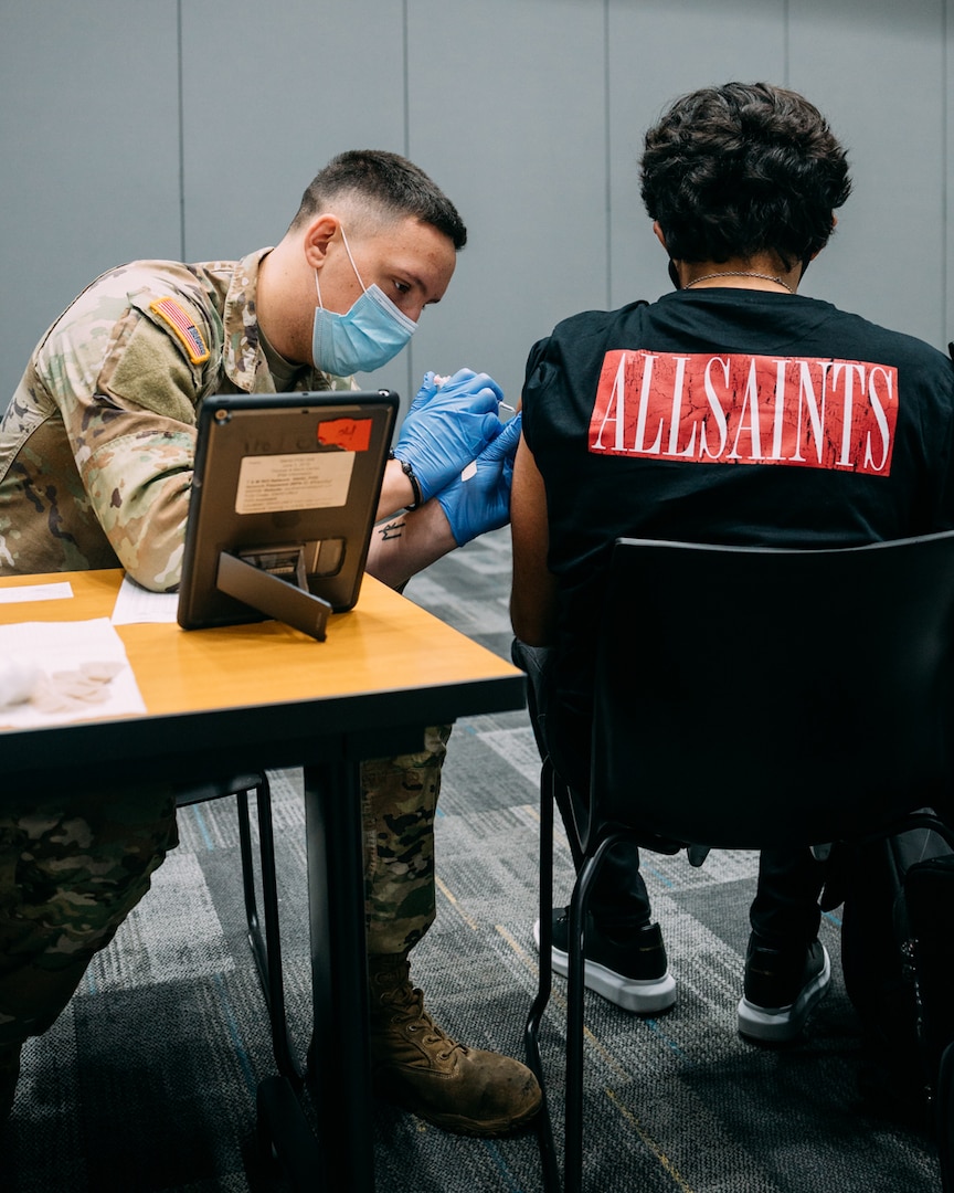 Nevada National Guard Spc. Austin Czarnecki of Joint Task Force 17 administers the Janssen vaccine to a patient at the College of Southern Nevada Cheyenne campus June 23, 2021 in Las Vegas. Soldiers and Airmen will vaccinate people at the Cheyenne and Charleston campuses through Sept. 30.