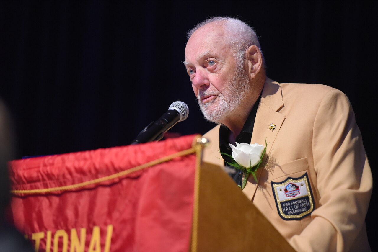 A man stands at a microphone on a podium.