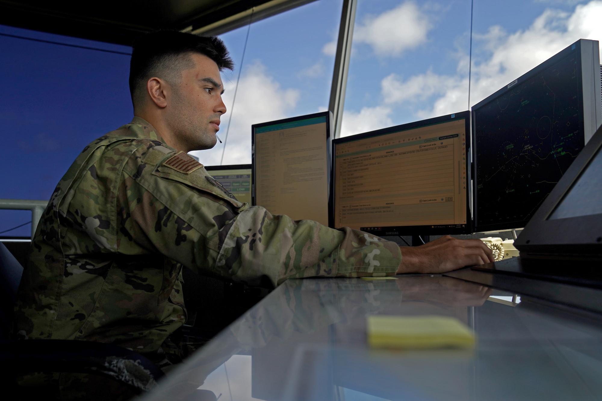 U.S. Air Force Staff Sgt. Brandon Ahuna, 81st Training Wing Operations Support Flight tower watch supervisor, works on his computer inside the Keesler Air Traffic Control tower at Keesler Air Force Base, Mississippi, June 25, 2021. The 81st TRW OSF traffics the aircraft on the Keesler flightline and the local airspace. (U.S. Air Force photo by Senior Airman Seth Haddix)