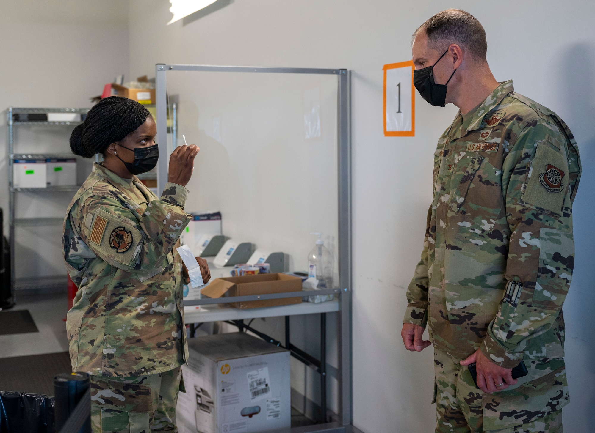 Capt. Tina Meyers, left, 87th Operational Medical Readiness Squadron clinical nurse, demonstrates COVID-19 test swabs to Col. Matt Husemann, 436th Airlift Wing commander, at the Baltimore/Washington International Thurgood Marshall Airport in Baltimore, June 27, 2021. The Patriot Express COVID-19 testing site, operated by Team Dover and other Air Mobility Command Airmen since November 2020, provides on-site, rapid testing for individuals traveling to overseas duty locations. (U.S. Air Force photo by Airman 1st Class Cydney Lee)