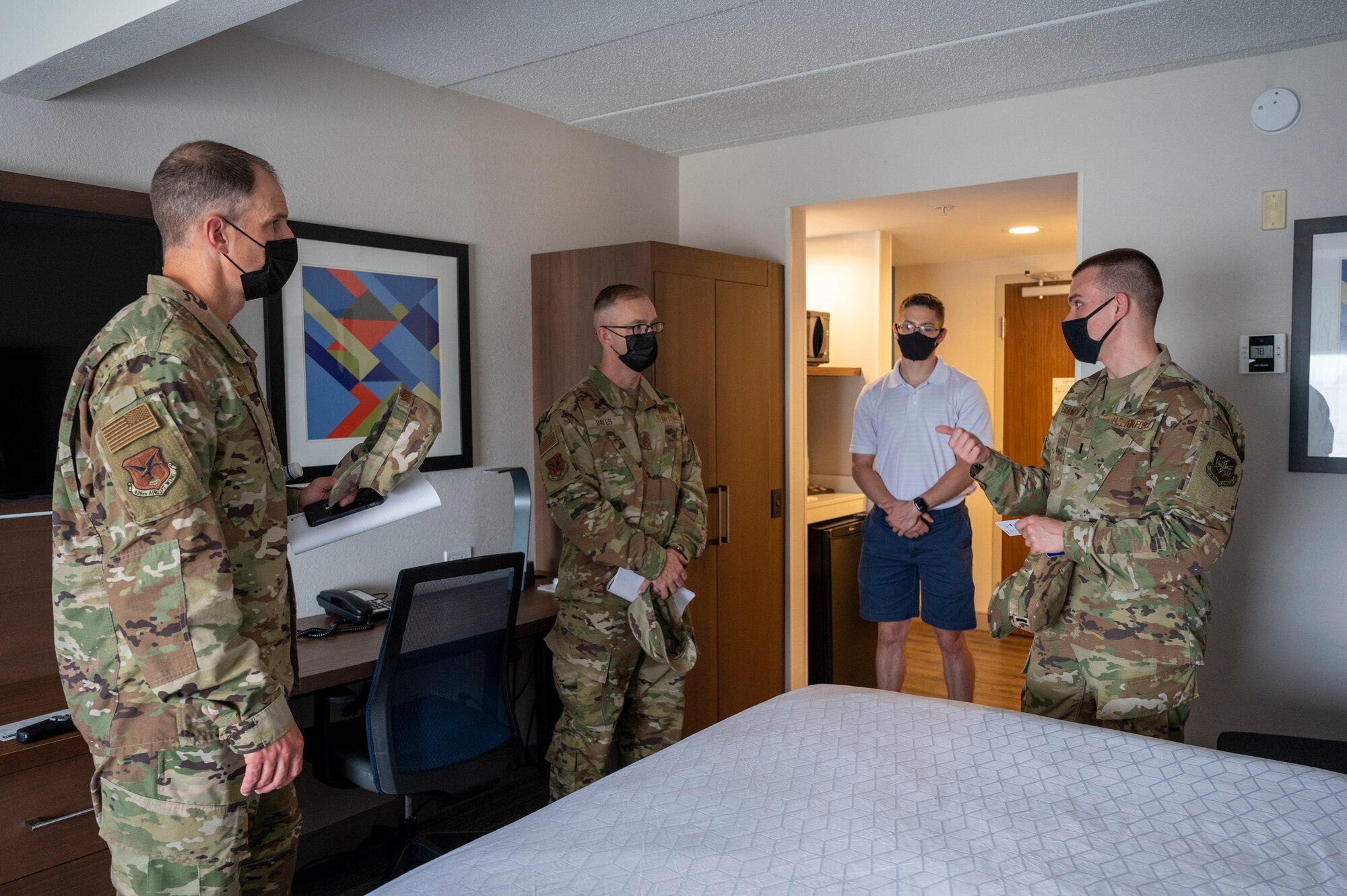From the left, Col. Matt Husemann, 436th Airlift Wing commander, and Chief Master Sgt. Timothy Bayes, 436th AW command chief, speak with Airman 1st Class Nicholas Denegre, Patriot Express COVID-19 testing site support cell driver, and 2nd Lt. Nikolaus Bihlmeyer, Patriot Express COVID-19 testing site support cell officer in charge, at a hotel in Baltimore, June 27, 2021. The hotel serves as an isolation location for service members who test positive at the Patriot Express testing site. Team Dover and other Air Mobility Command Airmen have supported the mission since November 2020. (U.S. Air Force photo by Airman 1st Class Cydney Lee)