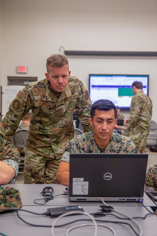 Troops work on laptops.