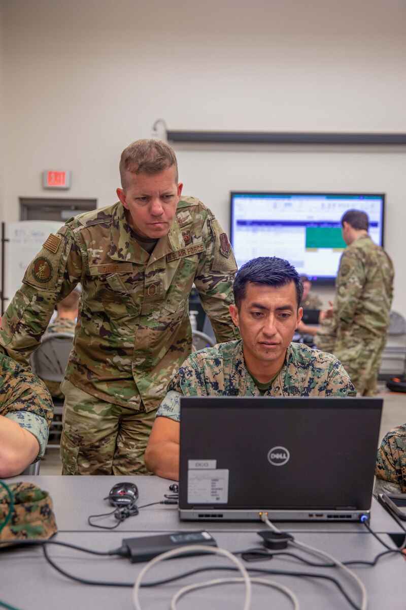 Troops work on laptops.