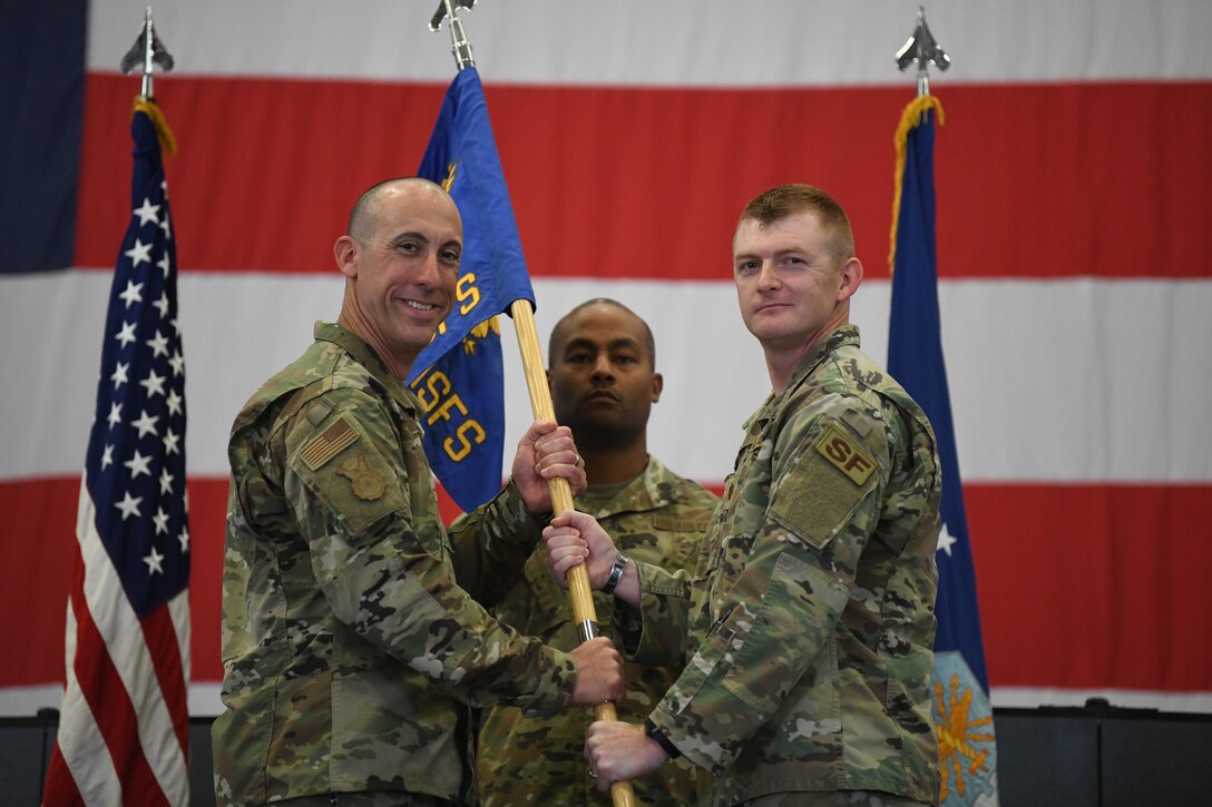 Col. Damian Schlussel, commander of the 90 Security Forces Group, passes the guidon to Maj. Bryan Tuttle, the incoming commander of the 790 Missile Security Forces Squadron, during the 790 MSFS Change of Command Ceremony on F.E. Warren Air Force Base, Wyoming, on June 29, 2021. The ceremony signified the transition of command from Lt. Col. Joseph Zrodlowski, the outgoing commander of the 790 MSFS, to Tuttle. (U.S. Air Force photo by Airman 1st Class Darius Frazier)