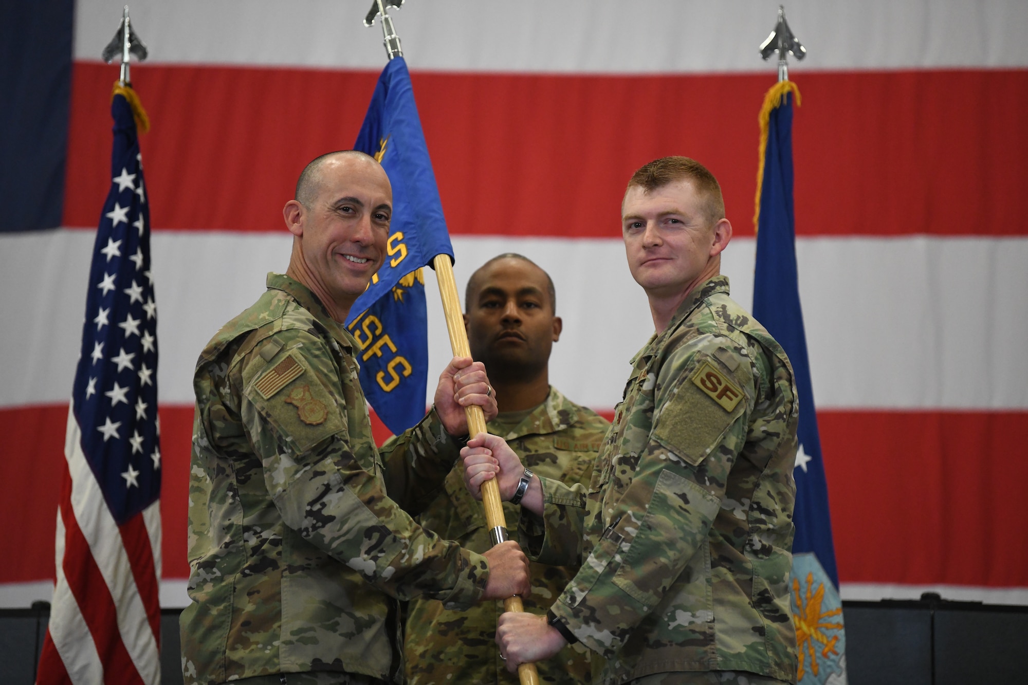 Col. Damian Schlussel, commander of the 90 Security Forces Group, passes the guidon to Maj. Bryan Tuttle, the incoming commander of the 790 Missile Security Forces Squadron, during the 790 MSFS Change of Command Ceremony on F.E. Warren Air Force Base, Wyoming, on June 29, 2021. The ceremony signified the transition of command from Lt. Col. Joseph Zrodlowski, the outgoing commander of the 790 MSFS, to Tuttle. (U.S. Air Force photo by Airman 1st Class Darius Frazier)