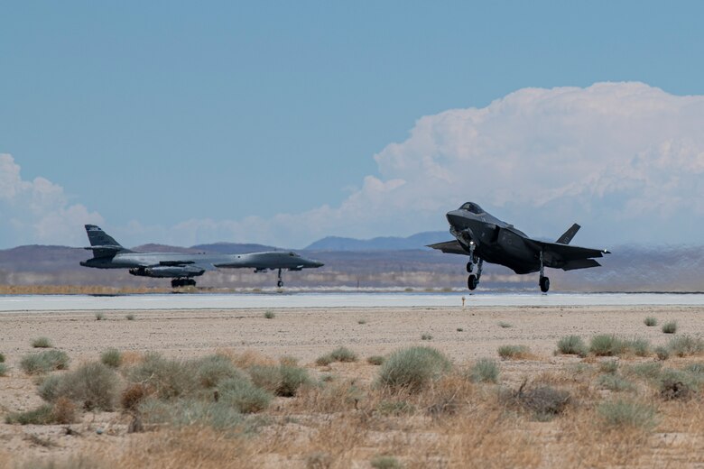 F-35 prepares to take off as a B-1 taxis on the runway behind it