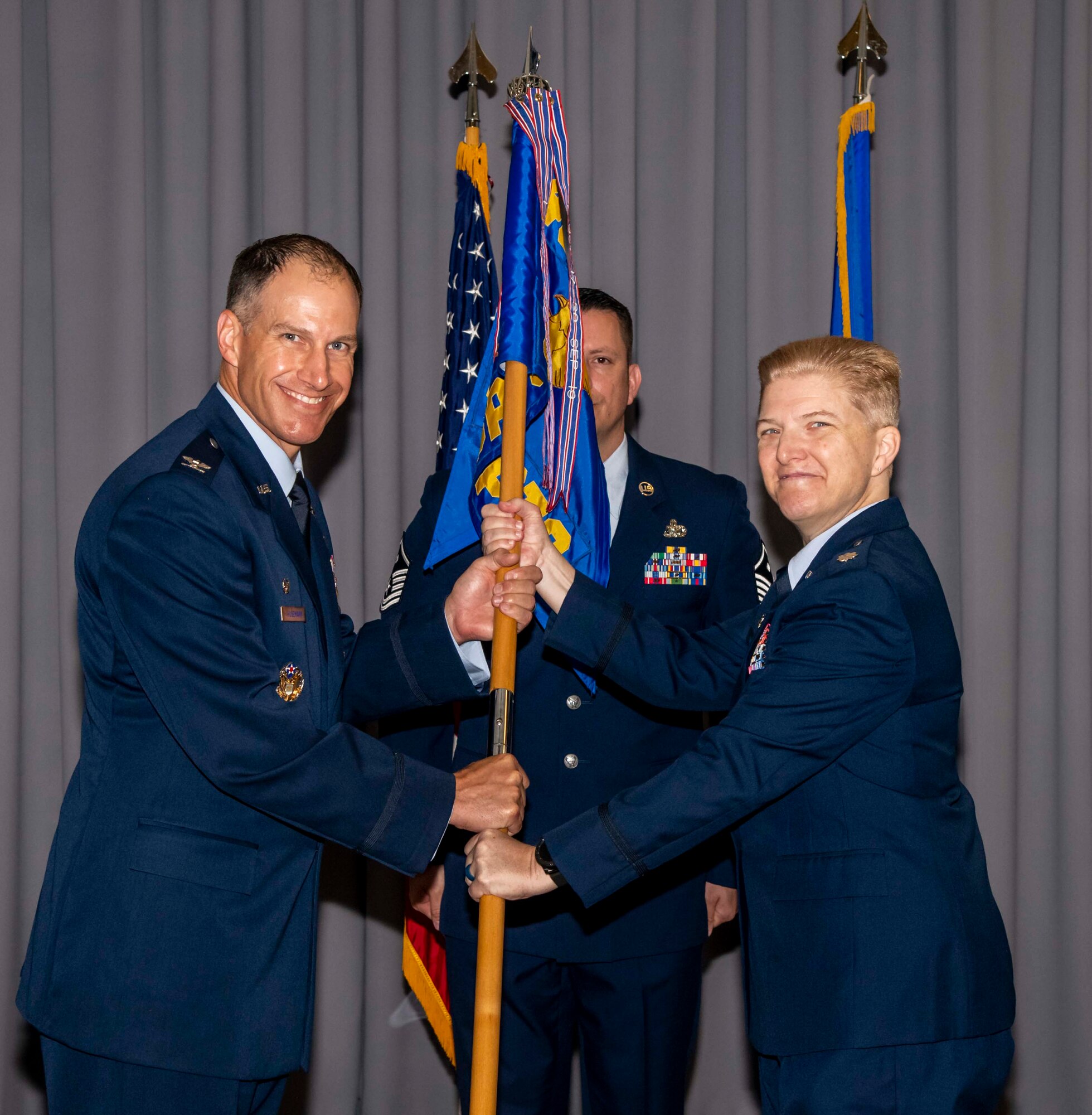 Col. Matt Husemann, left, 436th Airlift Wing commander, passes the guidon to Lt. Col. Gretchen Lewis during a change of command ceremony on Dover Air Force Base, Delaware, June 28, 2021. The ceremony saw Maj. Kevin Byram relinquish command to Lewis. (U.S. Air Force photo by Airman 1st Class Stephani Barge)