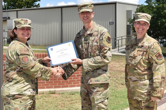 U.S. Air Force Col. Angelina Maguinness, 17th Training Group commander, and Chief Master Sgt. Breana Oliver, 17th TRG superintendent, presents 1st Lt. Cody Martin, 315th Training Squadron student, the 17th TRG Student of the Month award for May 2021, on Goodfellow Air Force Base, Texas, June 29, 2021. Martin worked hard for his award and has shown his dedication to his squadron and the training he received at Goodfellow. (U.S. Air Force photo by Senior Airman Jermaine Ayers)