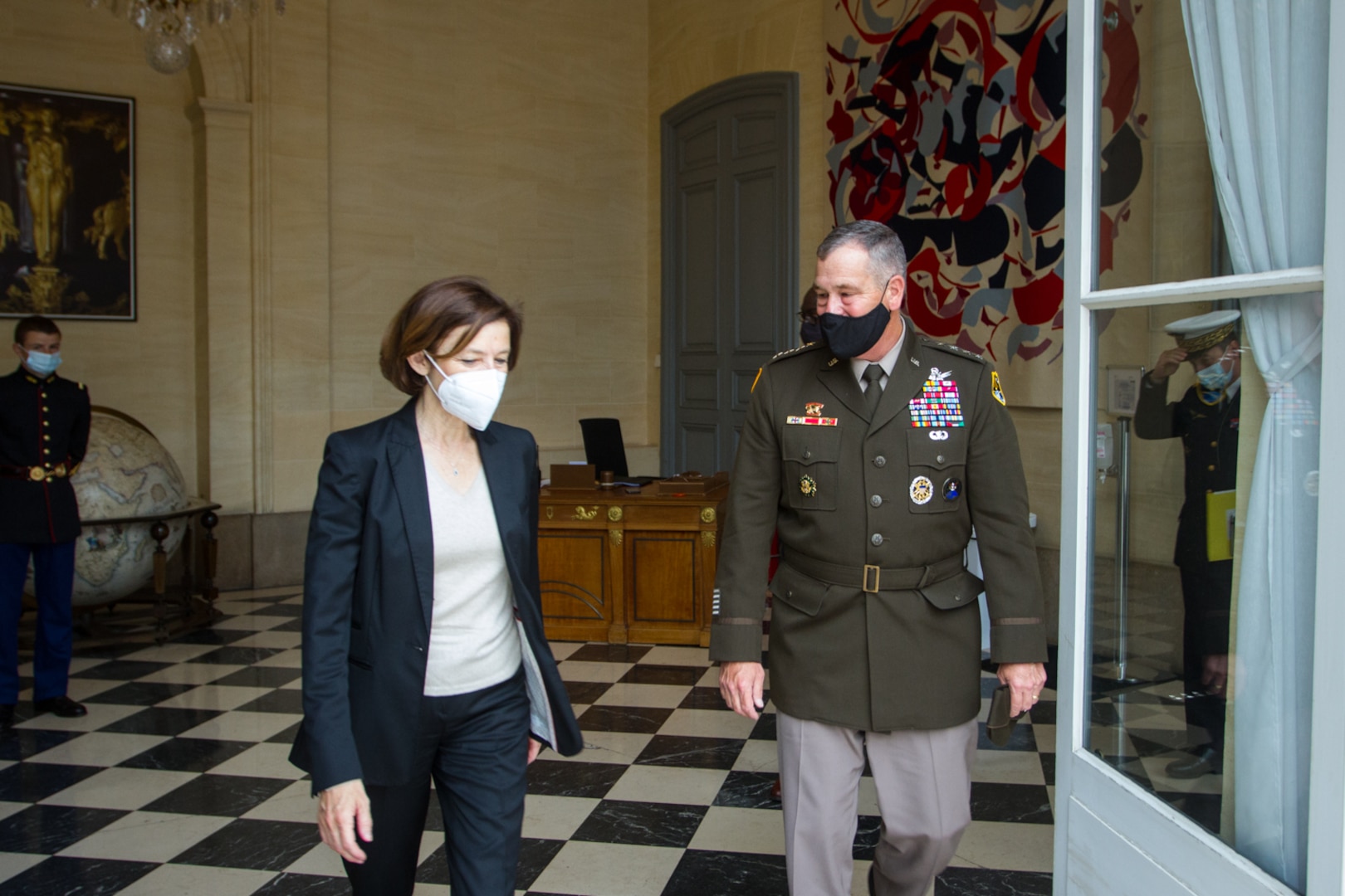 French defense minister and U.S. Army general walk.