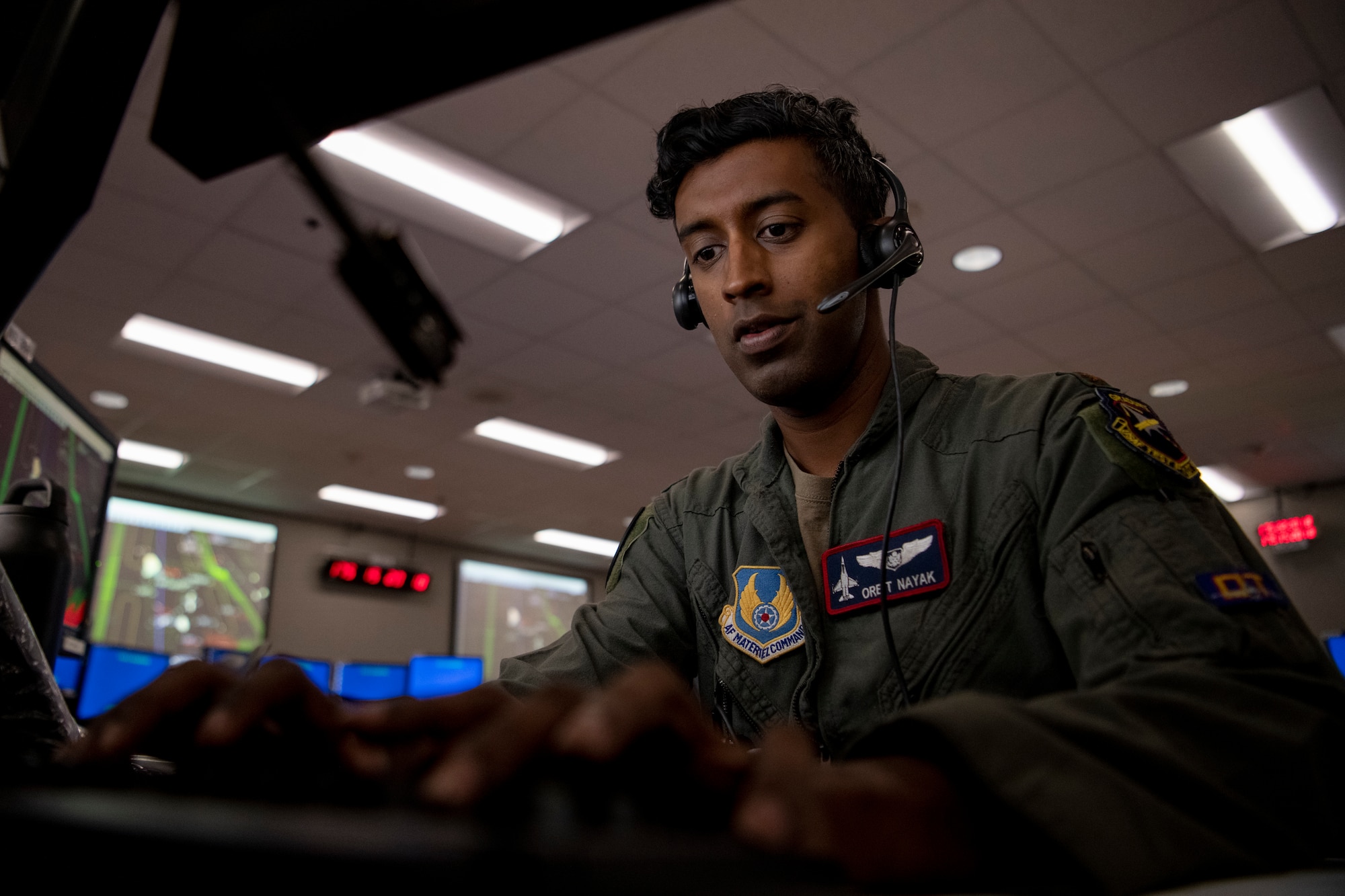 Airman works on computer with headset