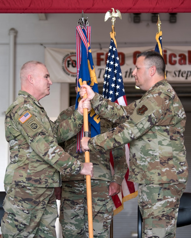 Chief Master Sgt. James Tongate (right), incoming state command chief of the Kentucky Air National Guard, accepts the Joint Forces Headquarters—Air guidon from Brig. Gen. Hal Lamberton (left), adjutant general of Kentucky, during a ceremony at the Kentucky Air National Guard Base in Louisville, Ky., May 15, 2021. Tongate previously served as the 123rd Airlift Wing's human resource advisor. (U.S. Air National Guard photo by Senior Airman Chloe Ochs)