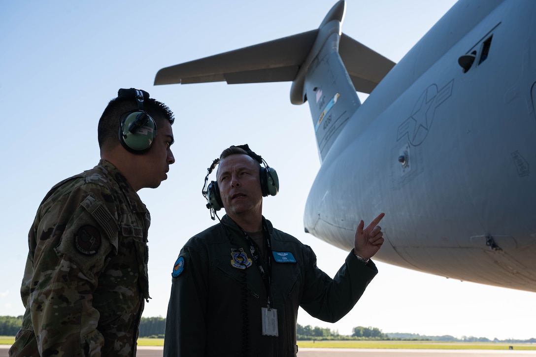 From the left, Staff Sgt. Israel Vazquez Rivera, 9th Airlift Squadron flight engineer, and Chief Master Sgt. Steven Foley, 9th AS superintendent, discuss pre-flight procedures before a local training mission at Dover Air Force Base, Delaware, June 23, 2021. The 9th AS routinely trains to provide global reach with unique outsized and oversized airlift capability on the C-5M Super Galaxy. (U.S. Air Force photo by Senior Airman Faith Schaefer)