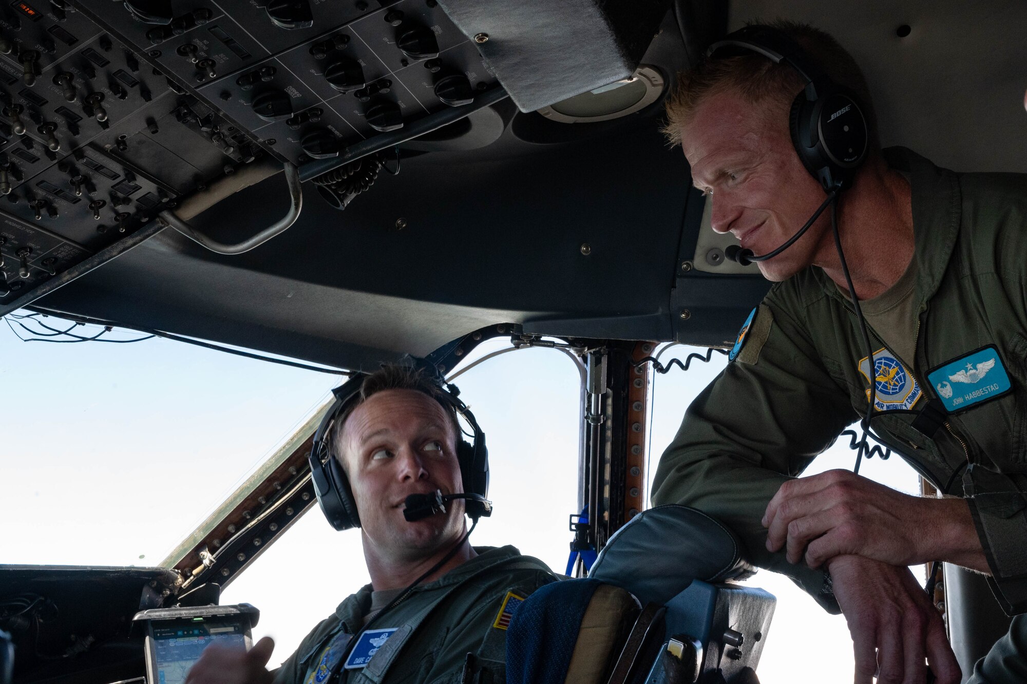 From the left, Lt. Cols. David Caswell, 9th Airlift Squadron pilot, and John Habbestad, 9th AS commander, discuss the flight path aboard a C-5M Super Galaxy over Delaware, June 23, 2021. This flight commemorated Habbestad’s final flight as the 9th AS commander. (U.S. Air Force photo by Senior Airman Faith Schaefer)