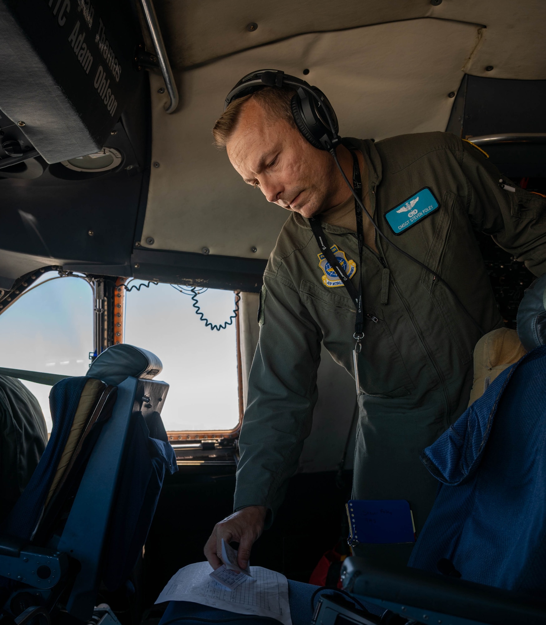 Chief Master Sgt. Steven Foley, 9th Airlift Squadron superintendent, checks flight orders during a local training flight on a C-5M Super Galaxy over New York, June 23, 2021. The 9th AS routinely trains to provide global reach with unique outsized and oversized airlift capabilities on the C-5. (U.S. Air Force photo by Senior Airman Faith Schaefer)