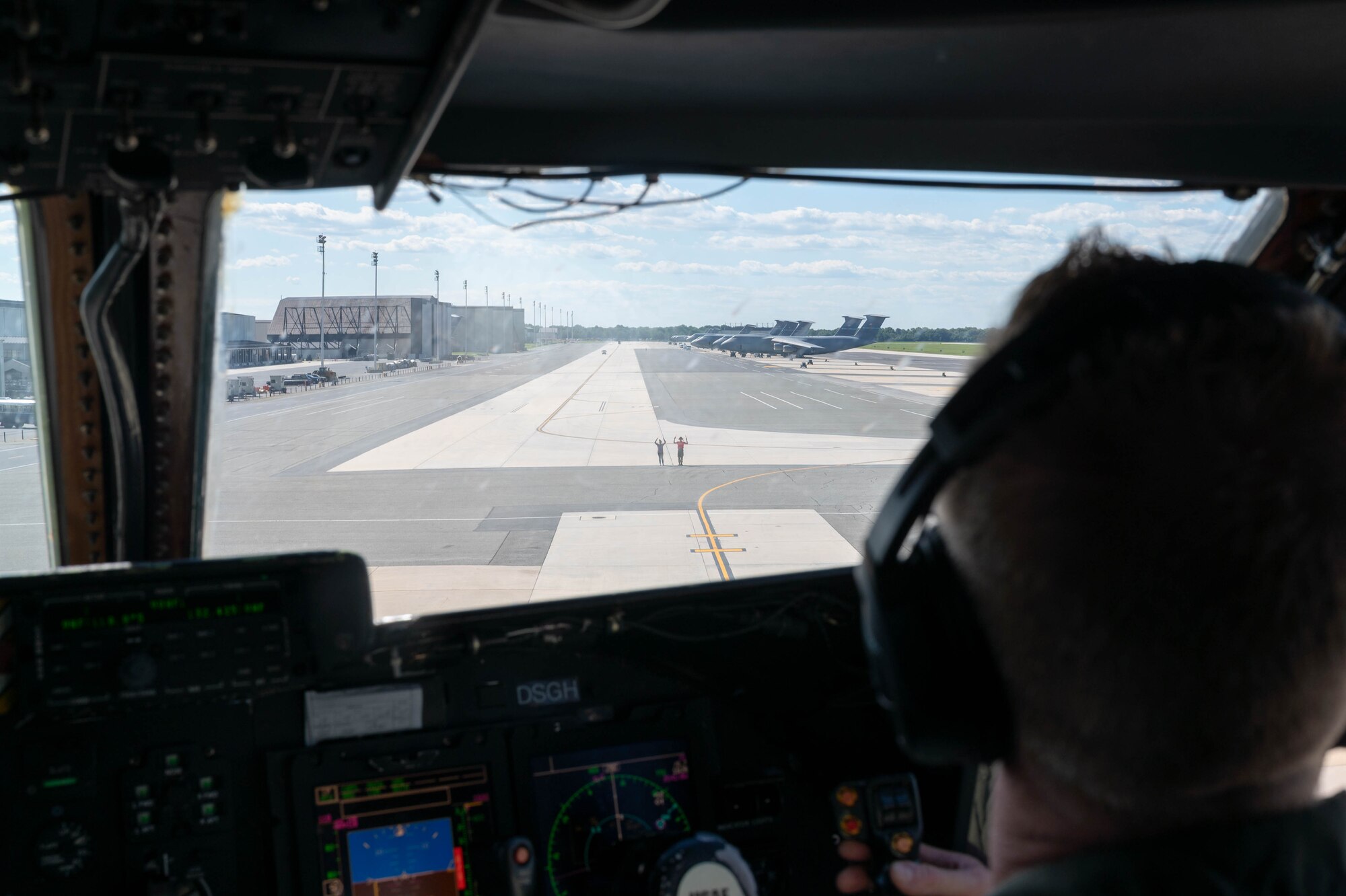 Lt. Col. John Habbestad, 9th Airlift Squadron commander, taxis a C-5M Super Galaxy while being marshalled by his family during his final flight as the 9th AS commander at Dover Air Force Base, Delaware, June 23, 2021. Habbestad served as 9th AS commander for two years. (U.S. Air Force photo by Senior Airman Faith Schaefer)