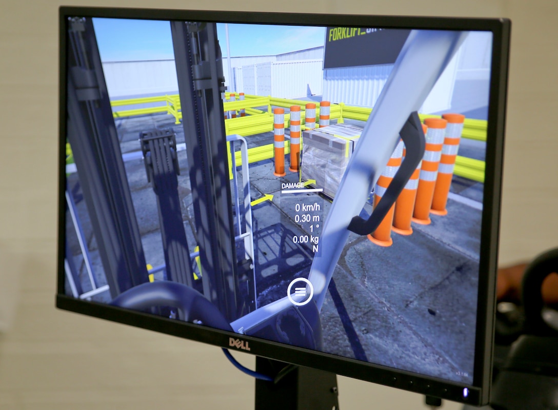 A new forklift simulator, complete with virtual reality goggles and a two-sided screen, allows for those in forklift training aboard Marine Corps Logistics Base Albany to see what they would see – and perform the same maneuvers – as if they were on a real forklift. Now in a dedicated space in the base’s Garrison Mobile Equipment branch, it provides a way to train forklift drivers with an added layer of safety. The ribbon was cut on the investment June 25. (U.S. Marine Corps photos by Jennifer Parks)