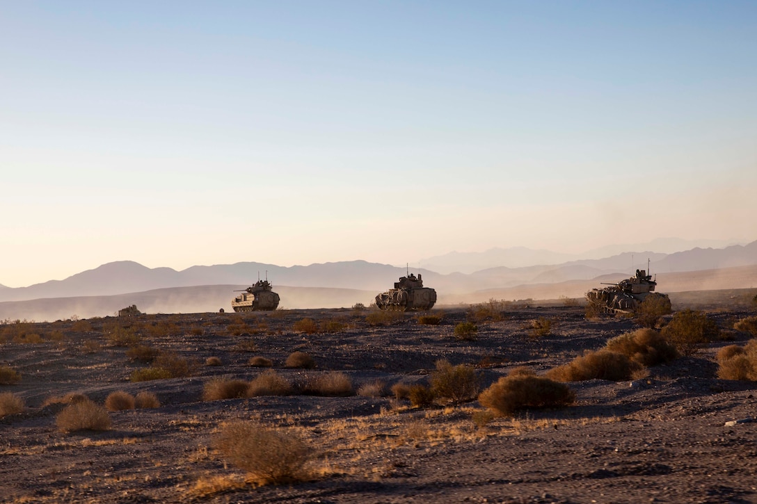 Tanks line up in the desert.