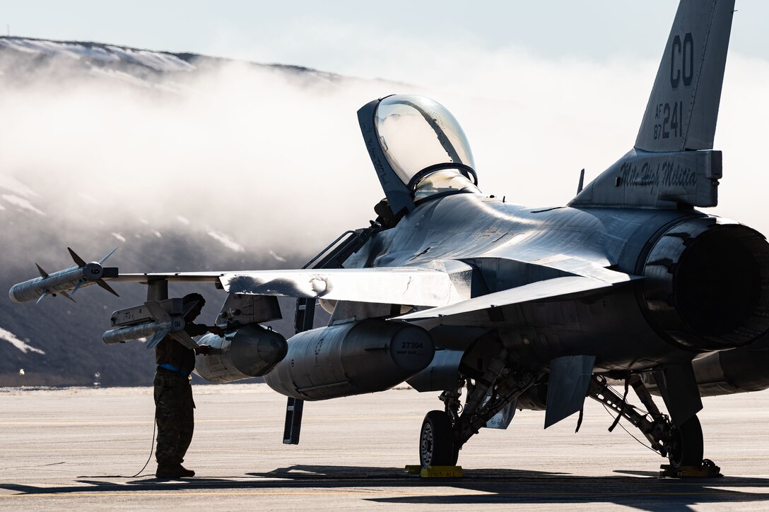 A United States Air Force aircraft maintenance technician conducts post flight inspection of a United States Air Force F-16 Fighting Falcon fighter jet during Exercise Amalgam Dart at Thule Air Base, Greenland, June 12, 2021.