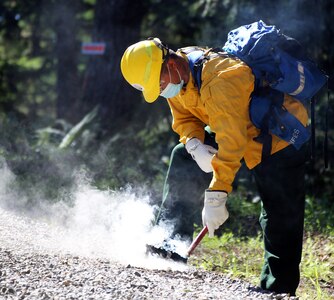 Washington National Guard Pfc. Xavier Cha, 1st Battalion, 161st Infantry Regiment, practices with a flare during wildfire training with the Washington Department of Natural Resources June 24, 2021, in Rainier, Wash. About 250 Washington National Guard members received firefighter training this spring in preparation for wildfire season.