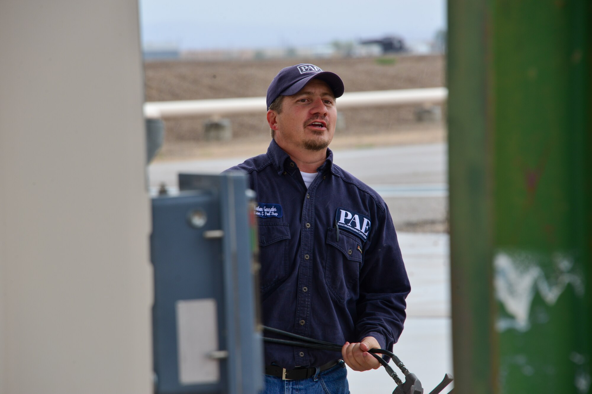 Man holds a fuel pump handles at Kirtland, AFB.