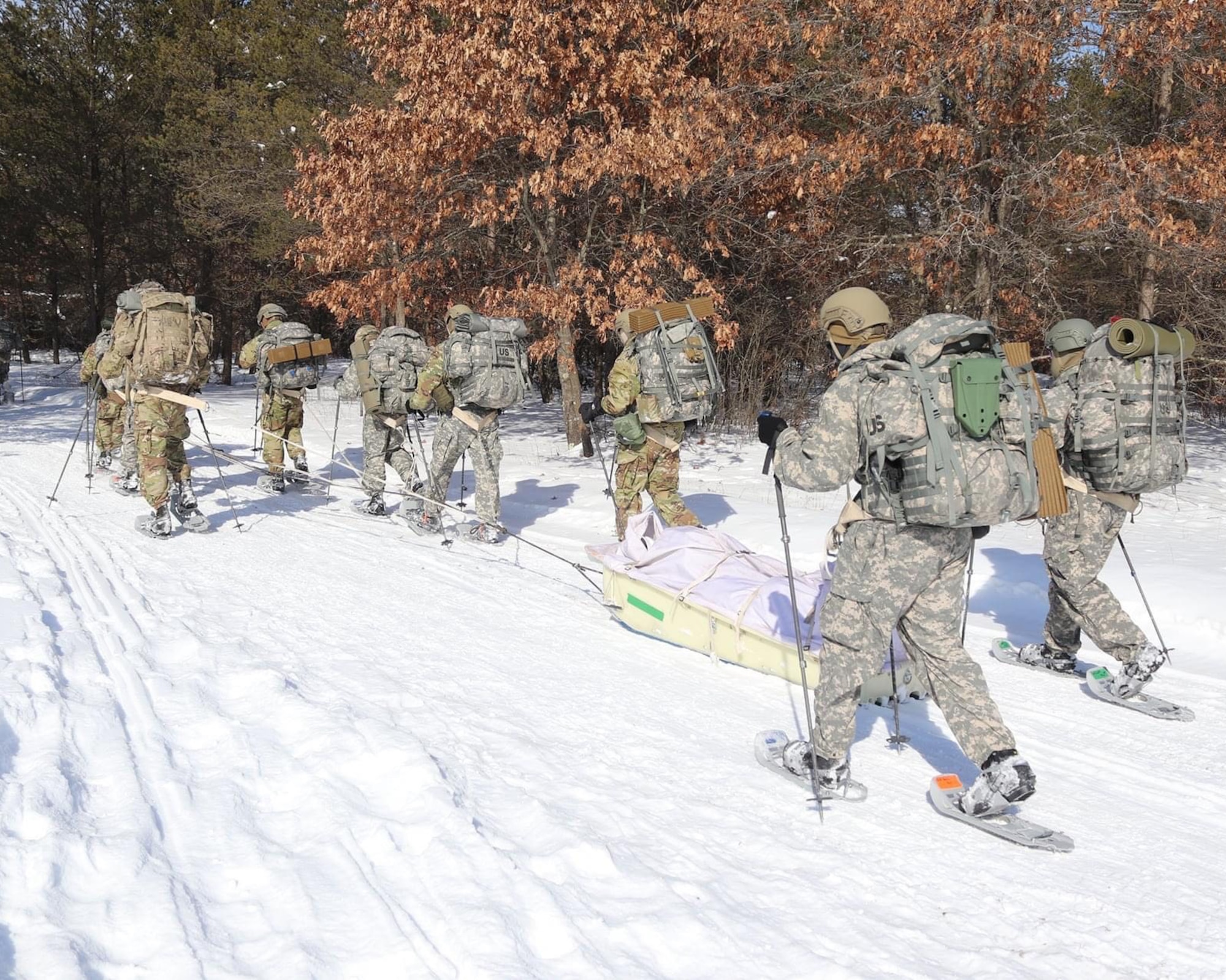 Airmen pulling ahkio sled at U.S. Army Cold Weather Operations Course.