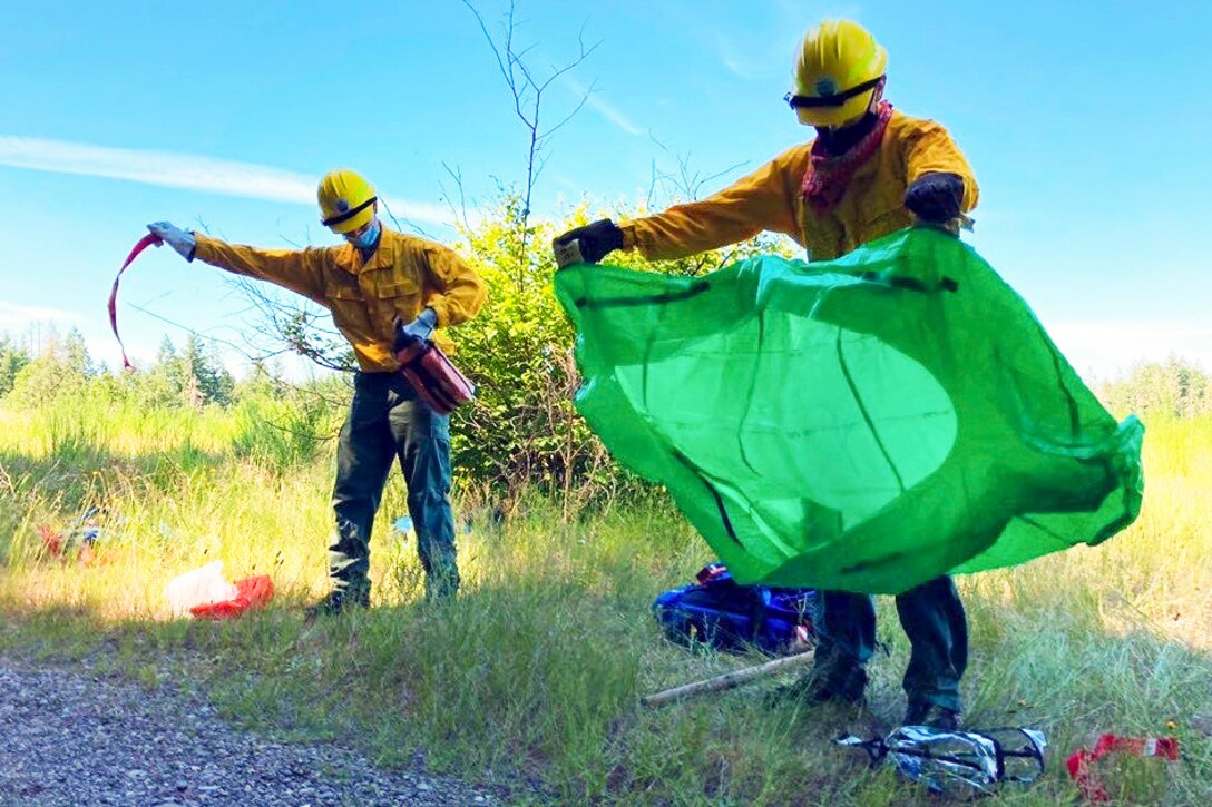 Two guardsmen build a fire shelter.