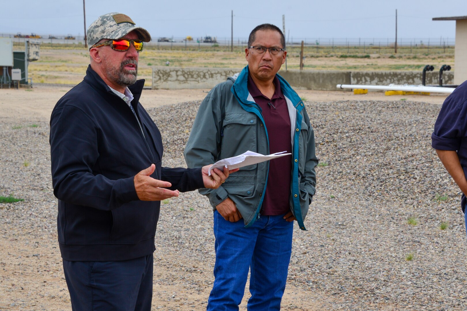 Man explains spill prevention protocol to a small group of people at Kirtland, AFB.