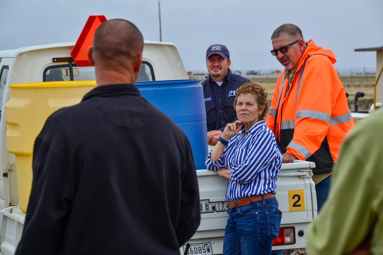 Man explains fire department involvement in the event of a spill to a small group of people at Kirtland, AFB.