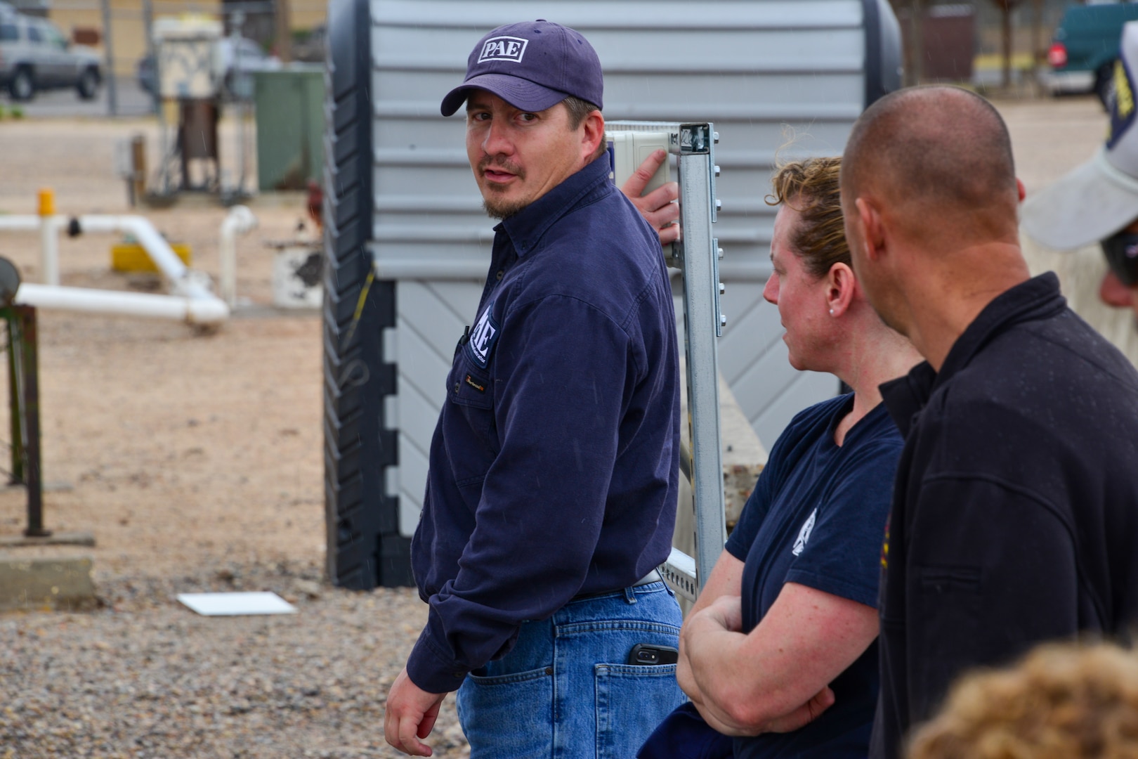 Man explains the emergency stop button to a small group of people at Kirtland, AFB.