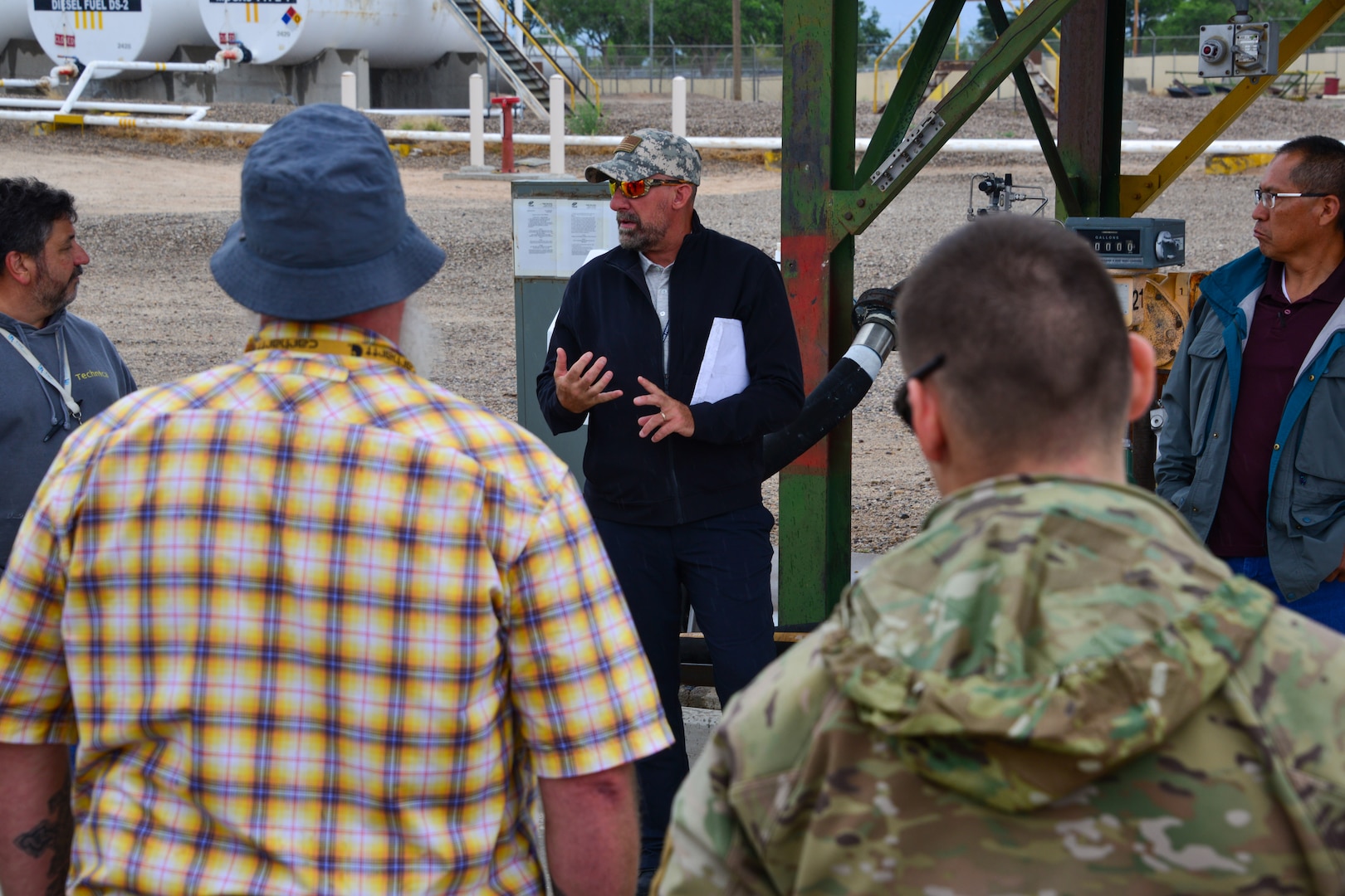 Man explaining spill prevention to a small group of people at Kirtland, AFB.