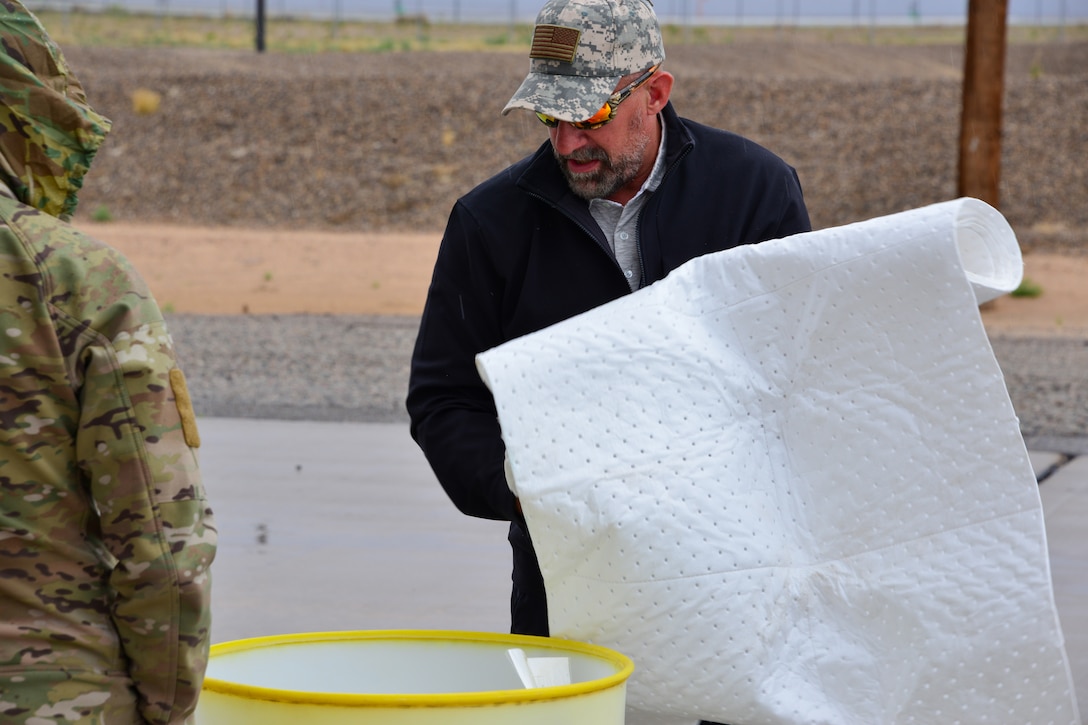 Man holds spill kit absorbent blanket at Kirtland, AFB.