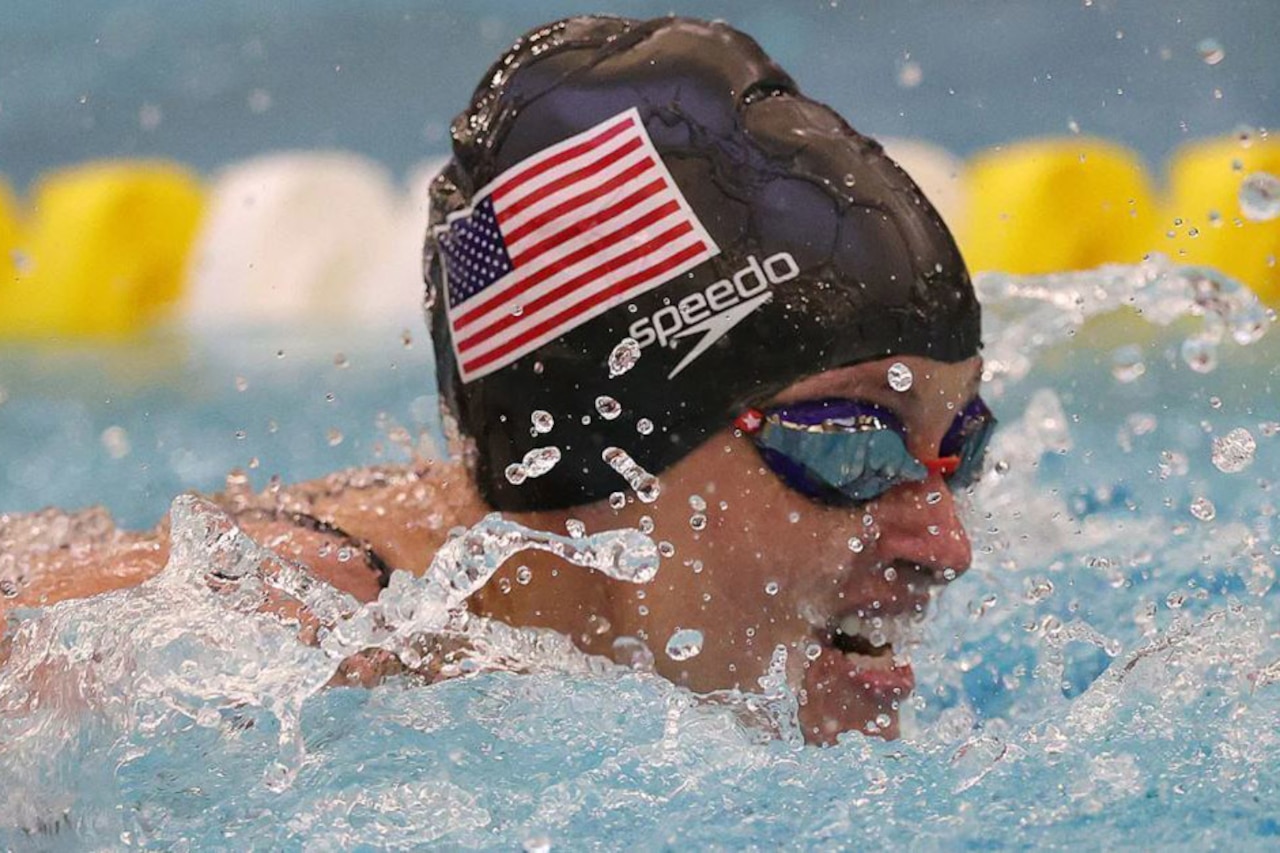 A soldier swims in a pool.