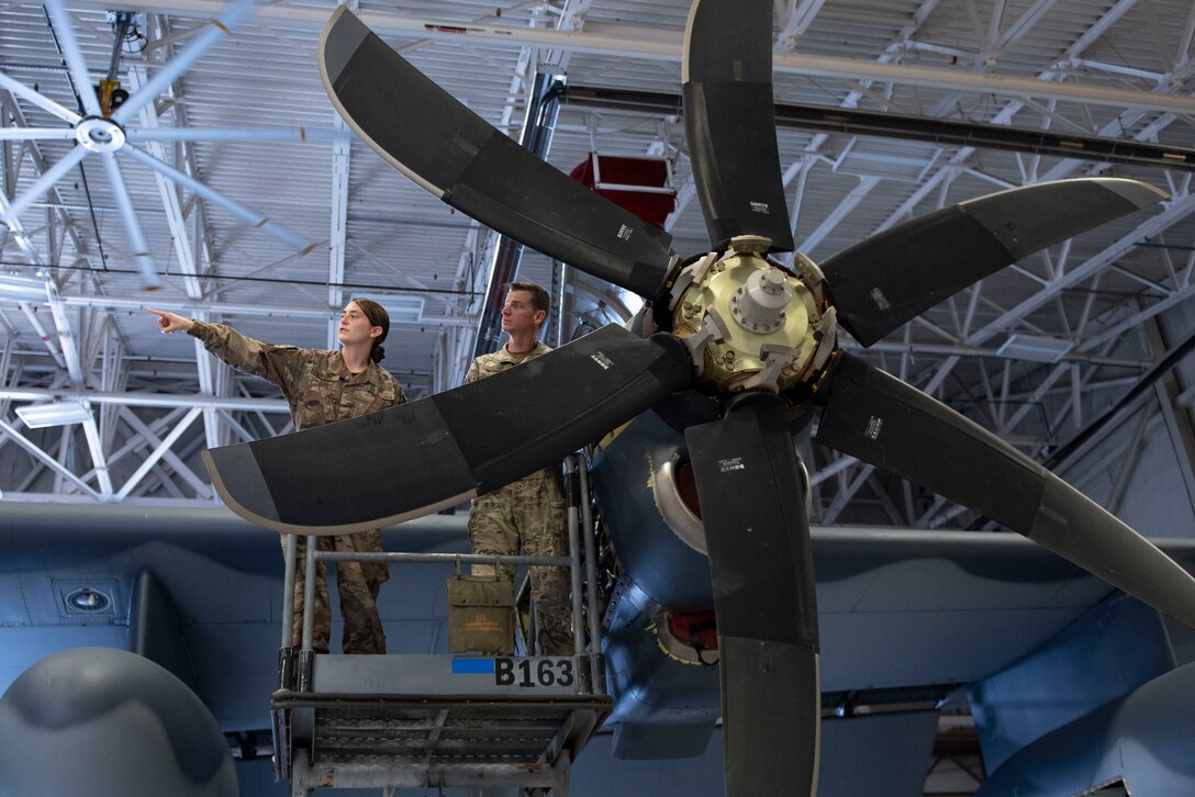 A photo of the base commander looking at an aircraft with an Airman.