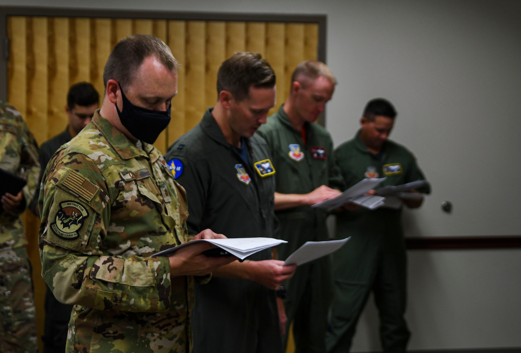 A photo of airmen holding bundles of paper