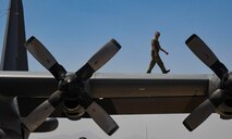 A photo of an airman walking on the wing of an aircraft