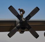 A photo of an airman standing on an aircraft engine