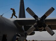 A photo of an airmen walking on top of an aircraft